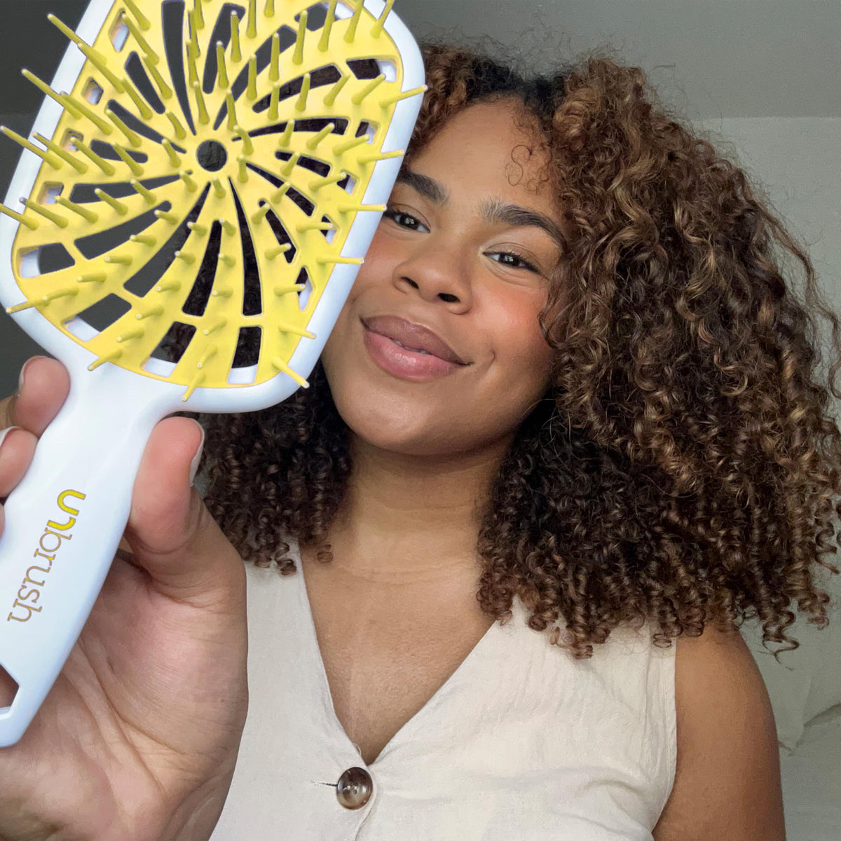 FHI Heat UNbrush Plus in a lifestyle scene smoothing curly hair for tame, defined curls