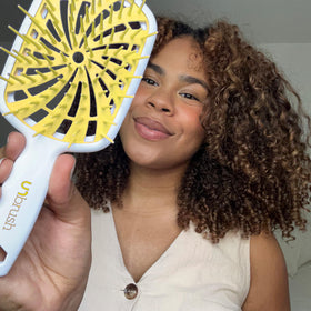 FHI Heat UNbrush Plus in a lifestyle scene smoothing curly hair for tame, defined curls