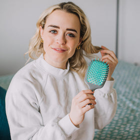 FHI Heat UNbrush size comparison beside a phone for portable styling convenience