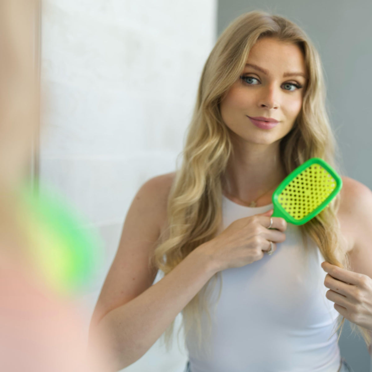 FHI Heat UNbrush next to toiletry items demonstrating convenient travel use