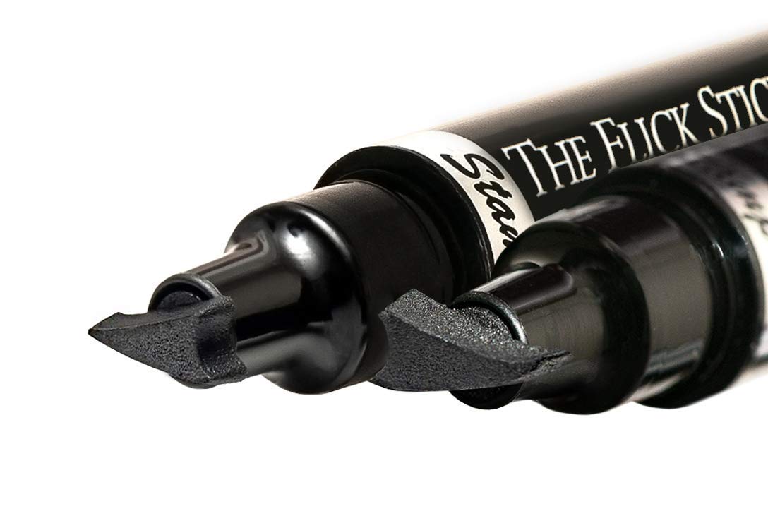 The Flick Stick open contents arrangement showing stamp, pen, and secure caps for storage