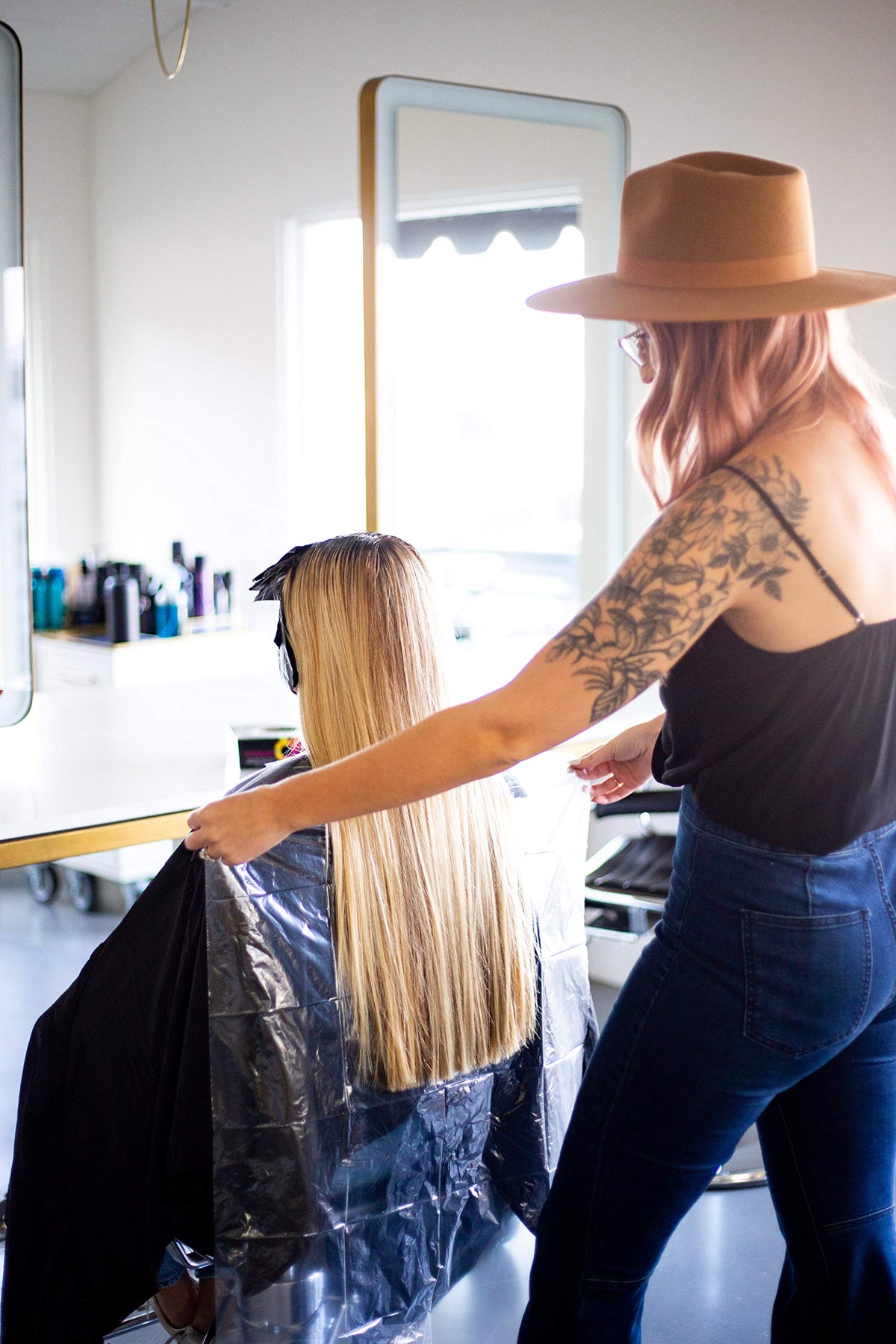 FRAMAR bib in a busy stylist station lifestyle scene signaling professional presentation
