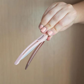FRAMAR clip held in hand to show scale and easy handling for salon precision