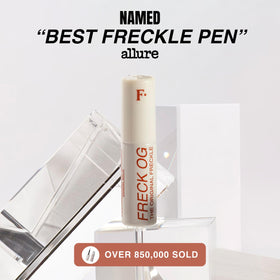 Freck Beauty pen next to wallet showing travel-ready compact size