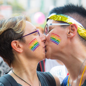 GCCL model at pride parade with rainbow stripes, bold visible celebration color