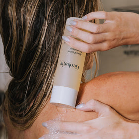 Person using Geologie in shower on upper back to reduce bacne and congestion