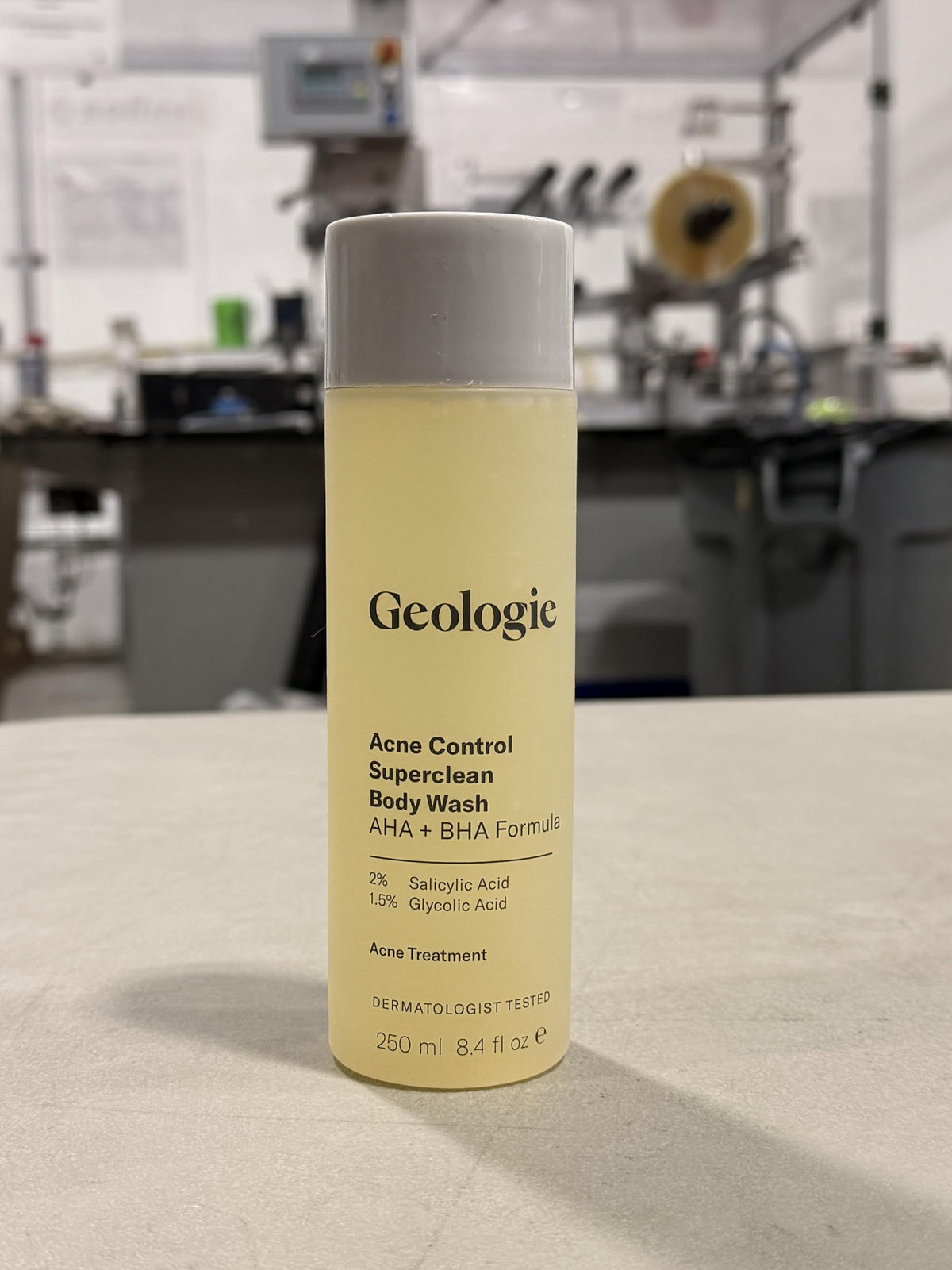 Geologie bottle in hand showing 8.4 fl oz scale and travel-friendly size