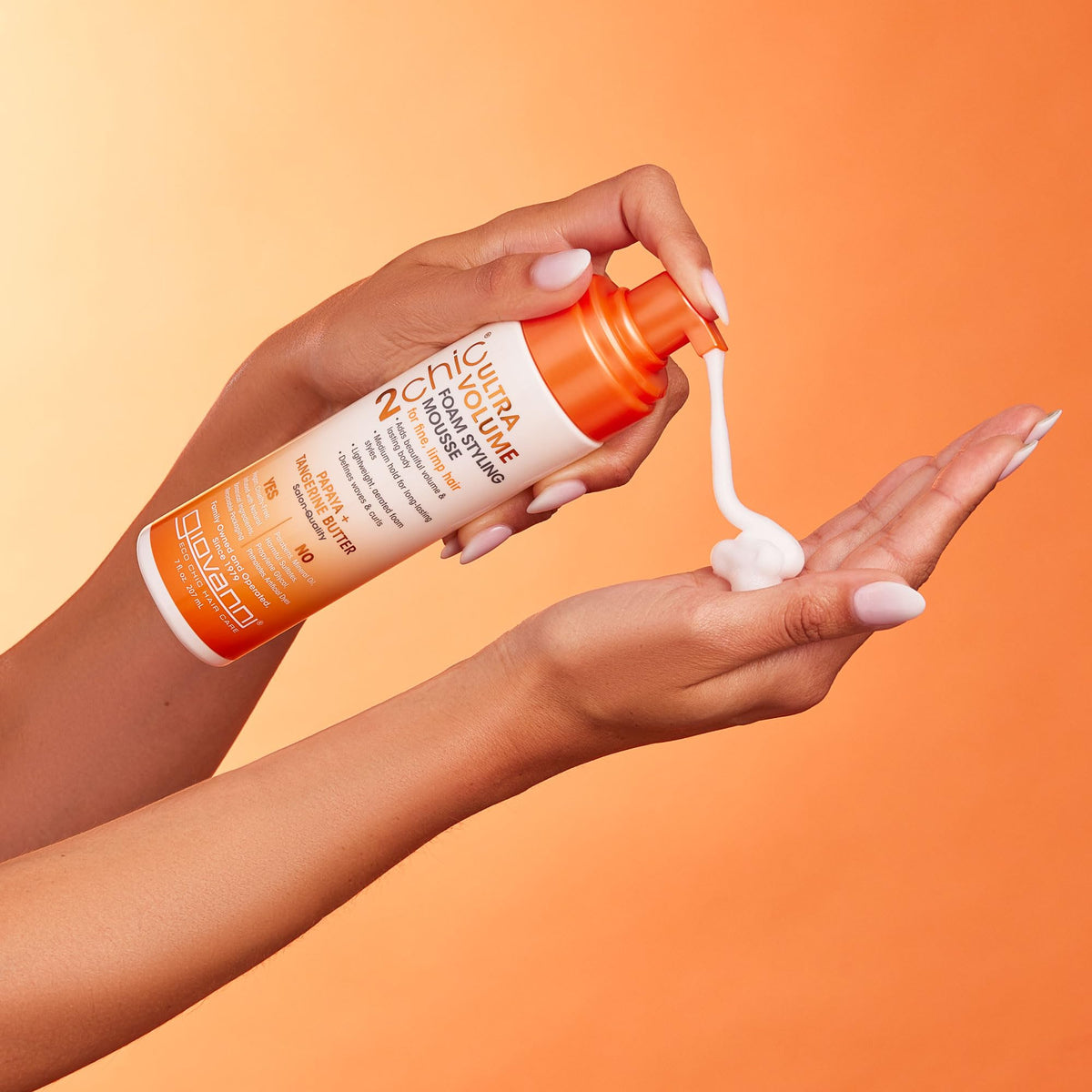 Model applying GIOVANNI mousse to damp hair for lift and definition