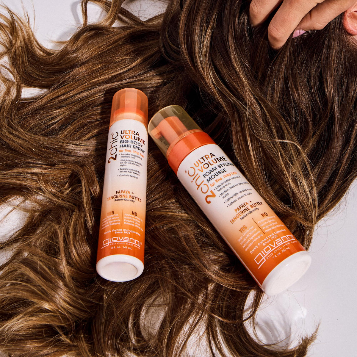 Stylist diffusing hair with GIOVANNI mousse for increased volume
