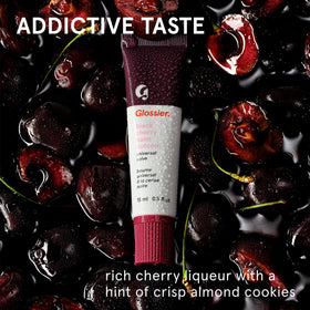 Glossier Balm Dotcom burgundy swipe on lips, buildable color enhances natural tone