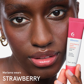 Glossier Balm Dotcom next to a hand for scale, 15ml travel-friendly tube for on-the-go care