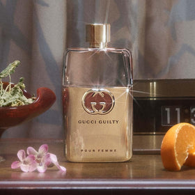 Gucci Guilty on dressing table with accessories suggesting daily wear