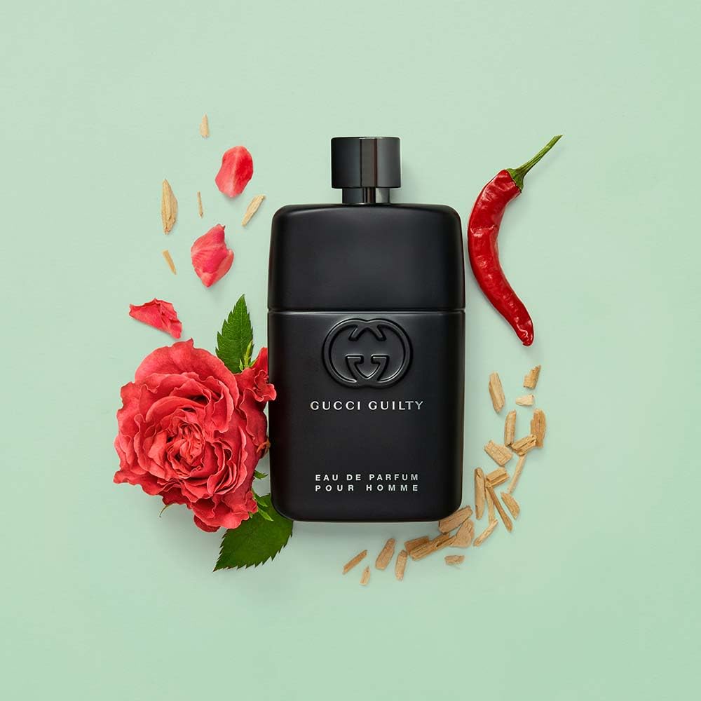 Composition flatlay with rose, pepper, and cedar to show the fragrance's key notes