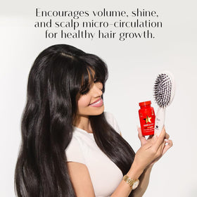 HAIRtamin brush held in hand to show lightweight ergonomic benefit