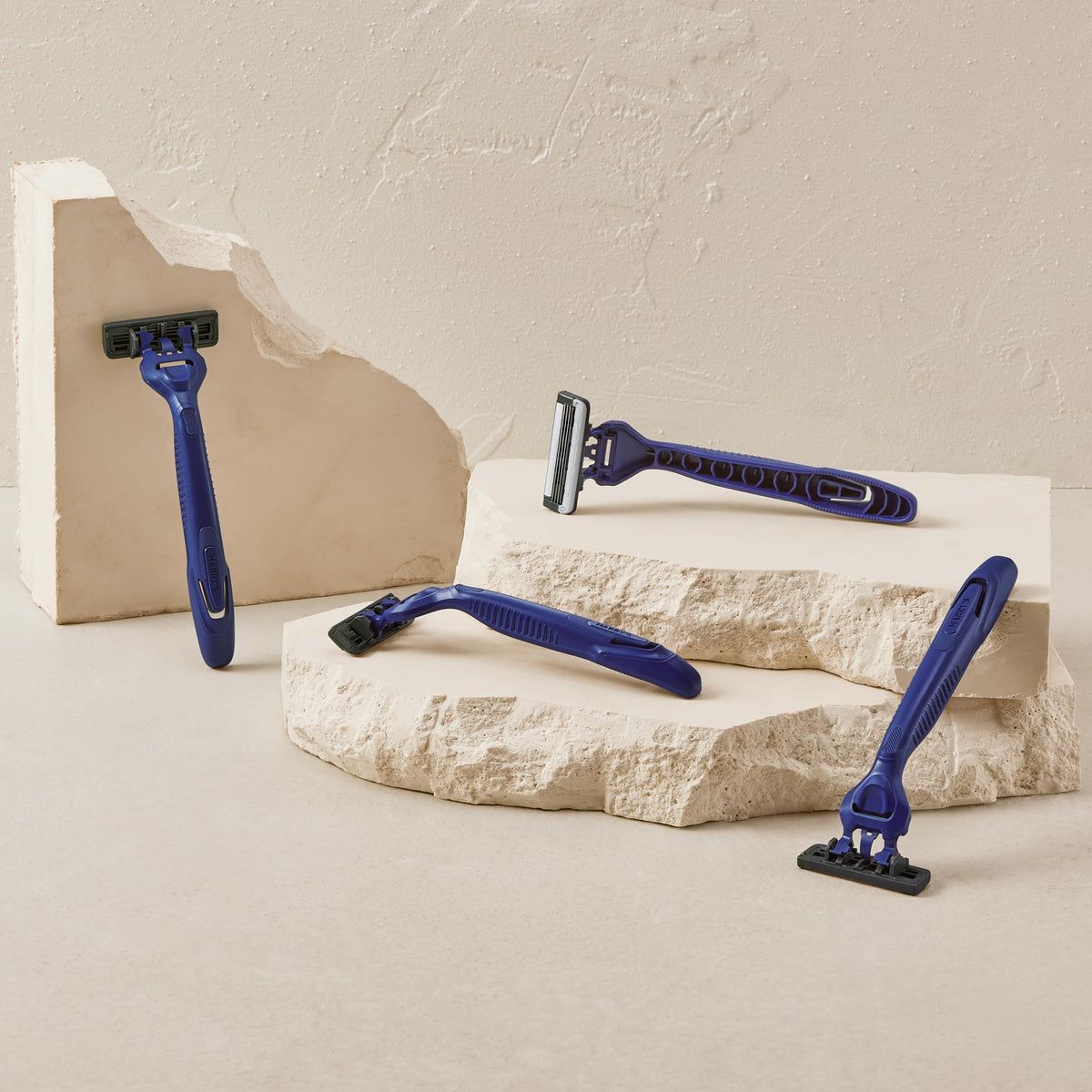 Harry's razor next to a coin showing compact size and portability