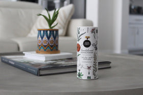 Herb & Root jar next to hand showing compact size and travel convenience
