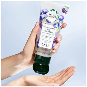Herbal Essences 6 oz tube next to a hand for scale showing travel-friendly size
