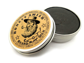 Honest Amish 2 oz tin held next to a coin illustrating compact size and travel-friendly convenience