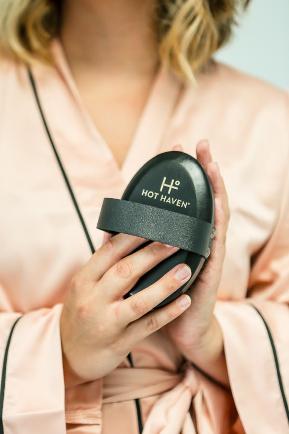 HOT HAVEN size comparison with hand showing compact, travel-friendly design