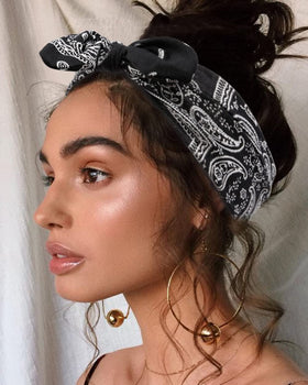 Huachi hand holding headband to show stretch and size versatility