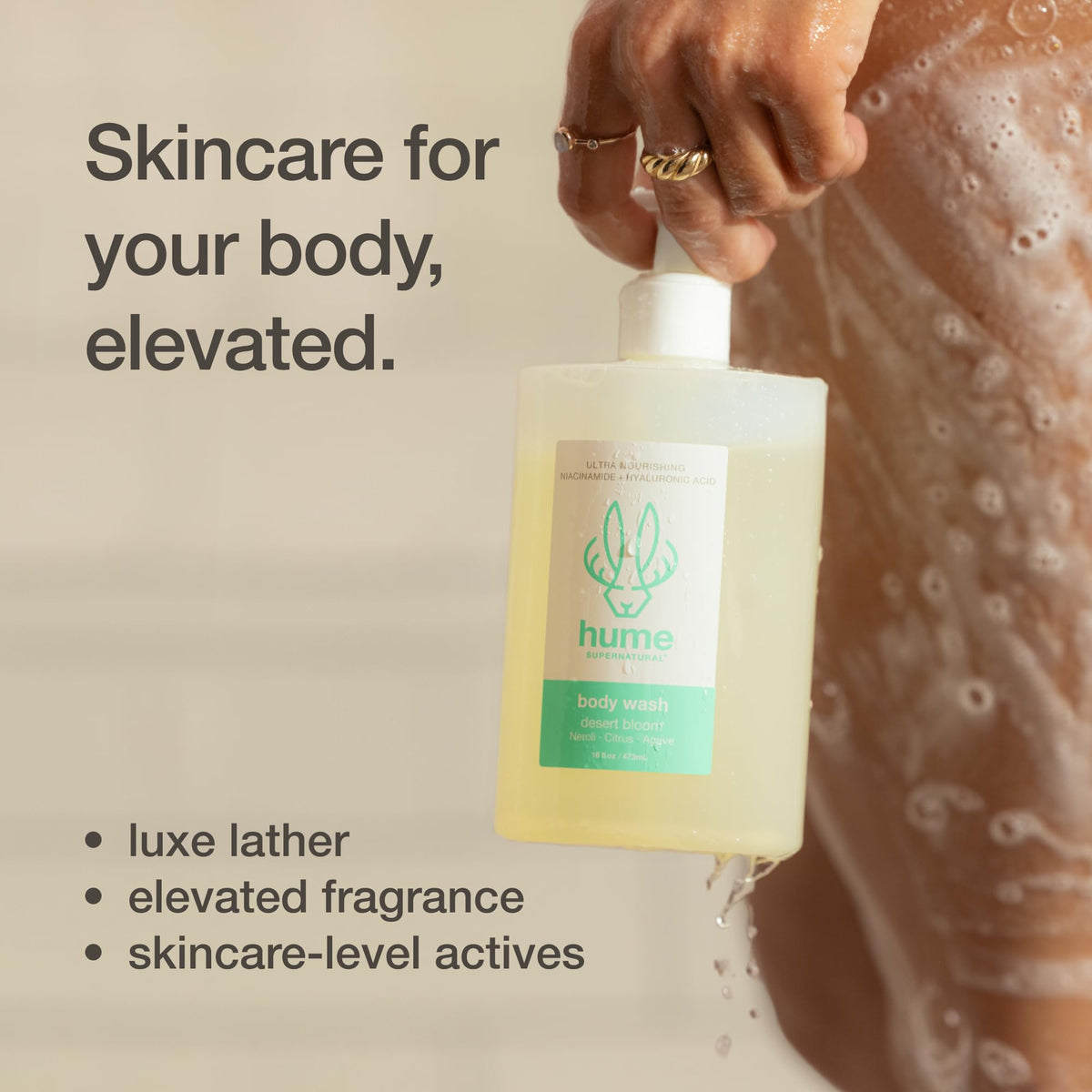 HUME SUPERNATURAL bottle held in hand showing 16 fl oz scale