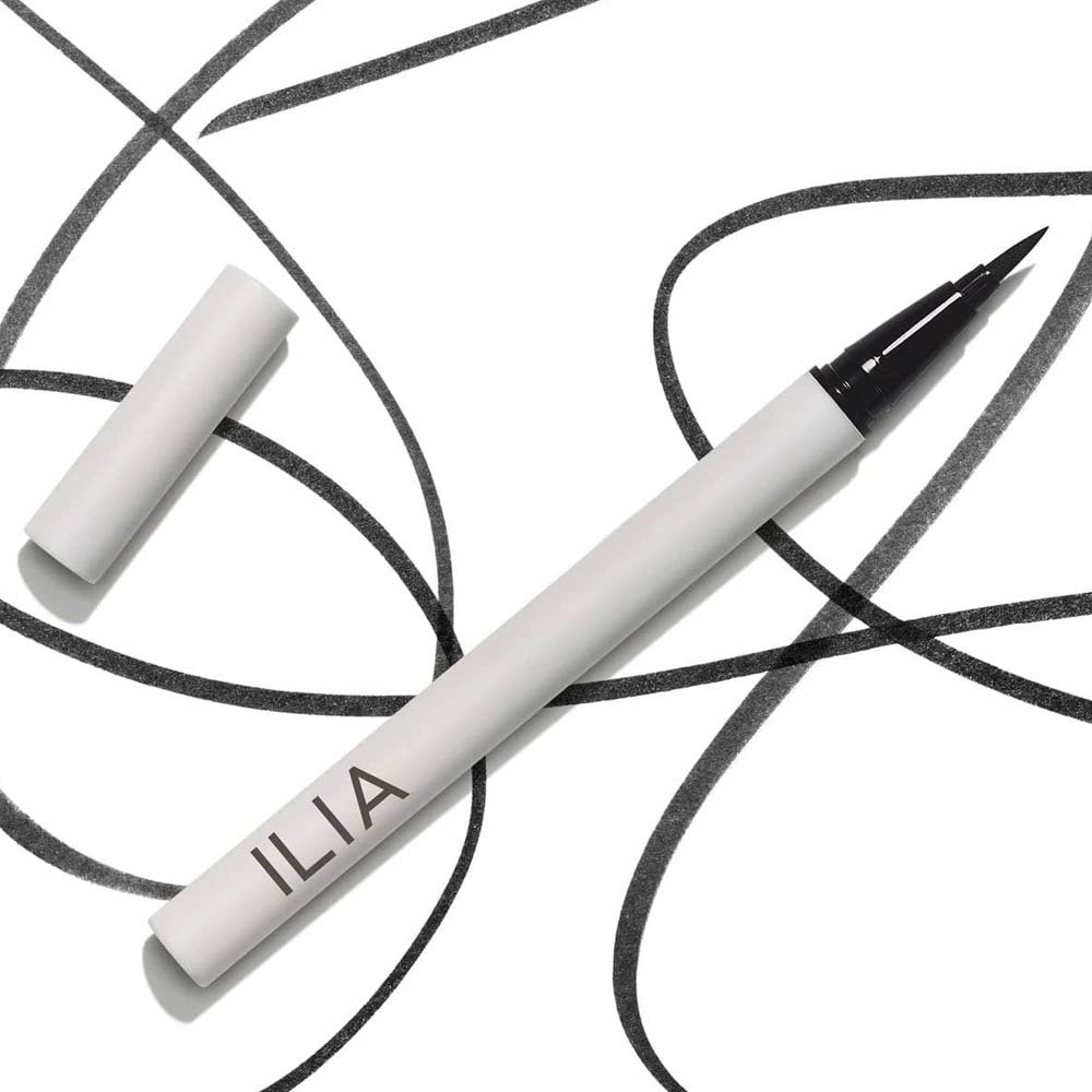 ILIA next to coin for scale showing compact travel-friendly size