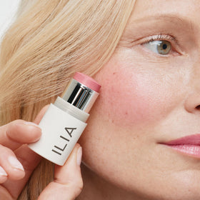 ILIA multi‑stick applied on lips showing soft pink tint and natural finish benefit