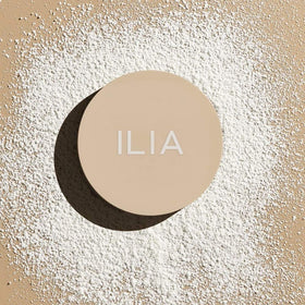 ILIA powder inside a makeup bag in lifestyle shot for on-the-go touch-up convenience