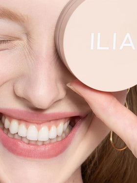 ILIA powder next to coin to show compact 0.32 oz size and portability benefit