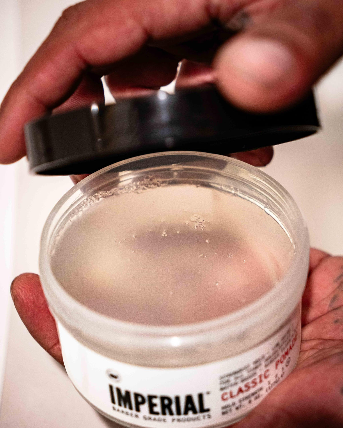 Imperial Barber Grade classic pomade being scooped onto hand, easy to spread and apply