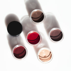 Inglot small jar beside a coin to show size and portability for travel and kit convenience