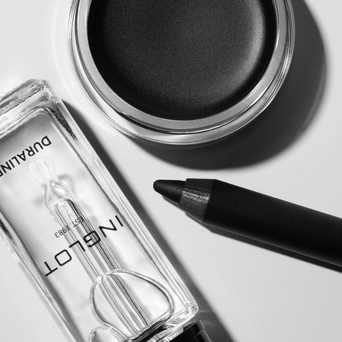 Inglot AMC gel eyeliner next to a coin for scale showing compact travel-friendly size