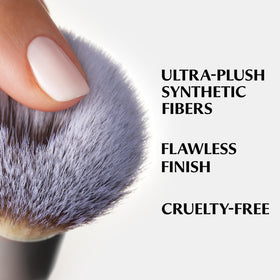 IT Cosmetics brush held in hand showing size and easy grip for travel convenience