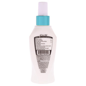 Stylist applying It’s a 10 mist during blow‑dry for smoother, frizz‑reduced hair