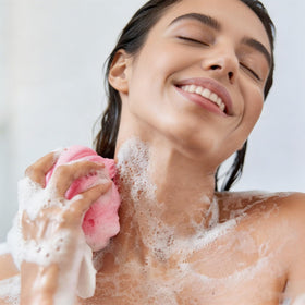 Jegruda mini loofah in hand beside travel bag demonstrating space-saving benefit