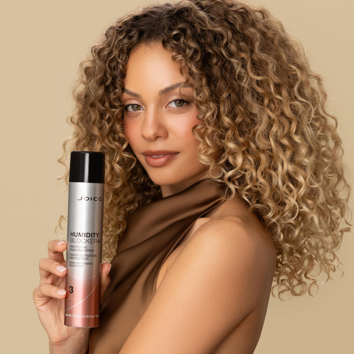 Joico bottle in hand for size comparison conveying travel-friendly 180 mL capacity