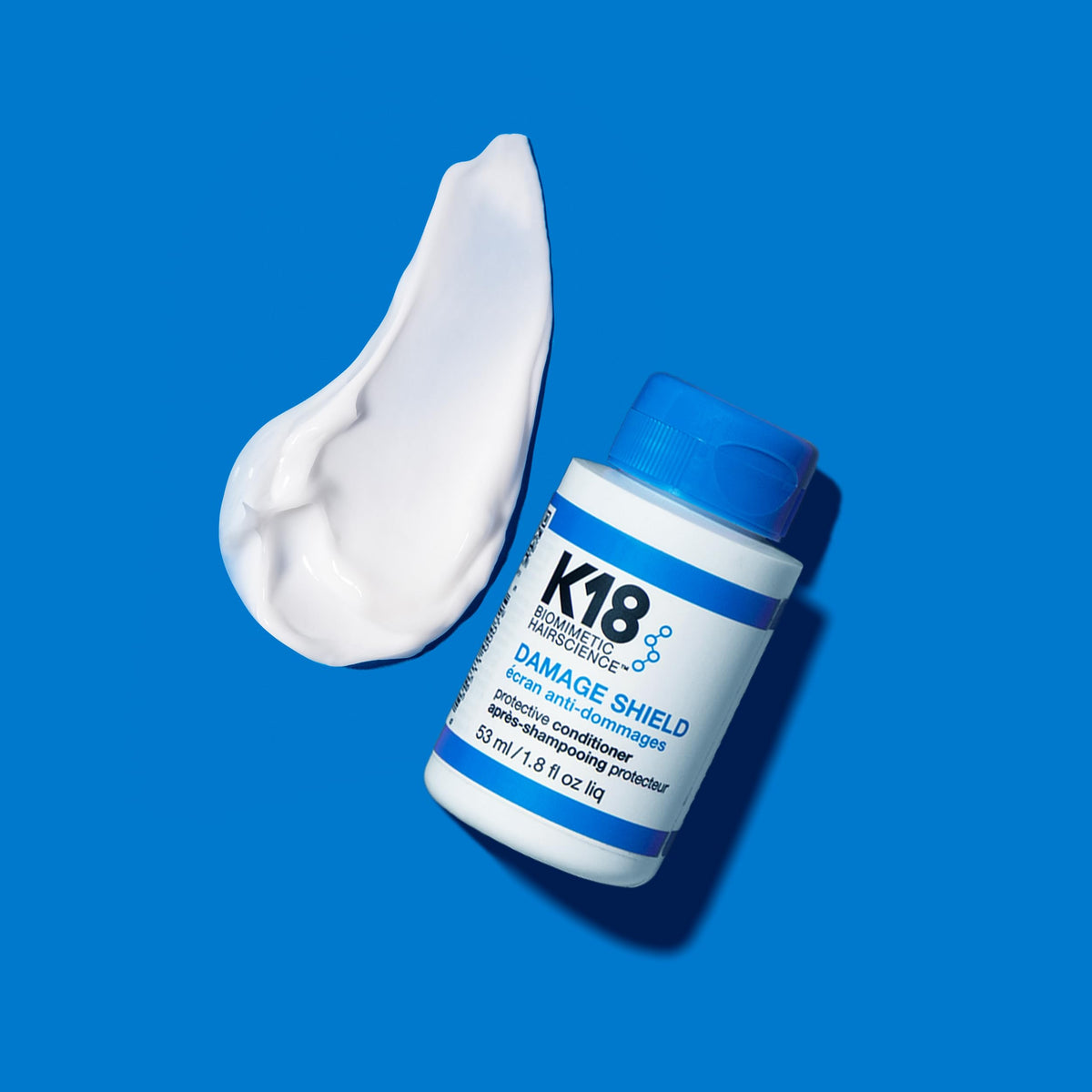 K18 conditioner texture close-up on fingers, highlights lightweight creamy finish and spreadability