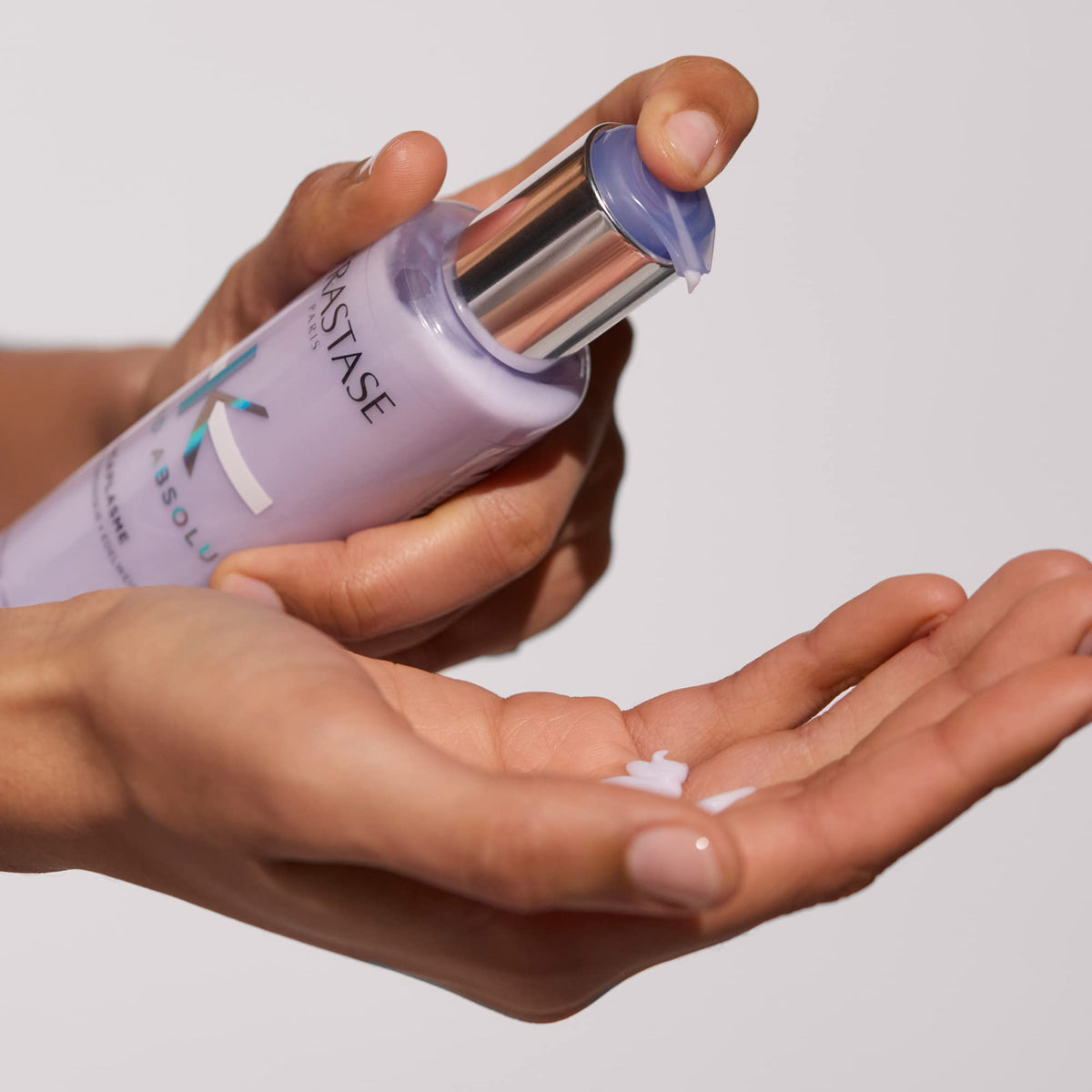 KÉRASTASE serum on bathroom shelf styled with blond haircare products