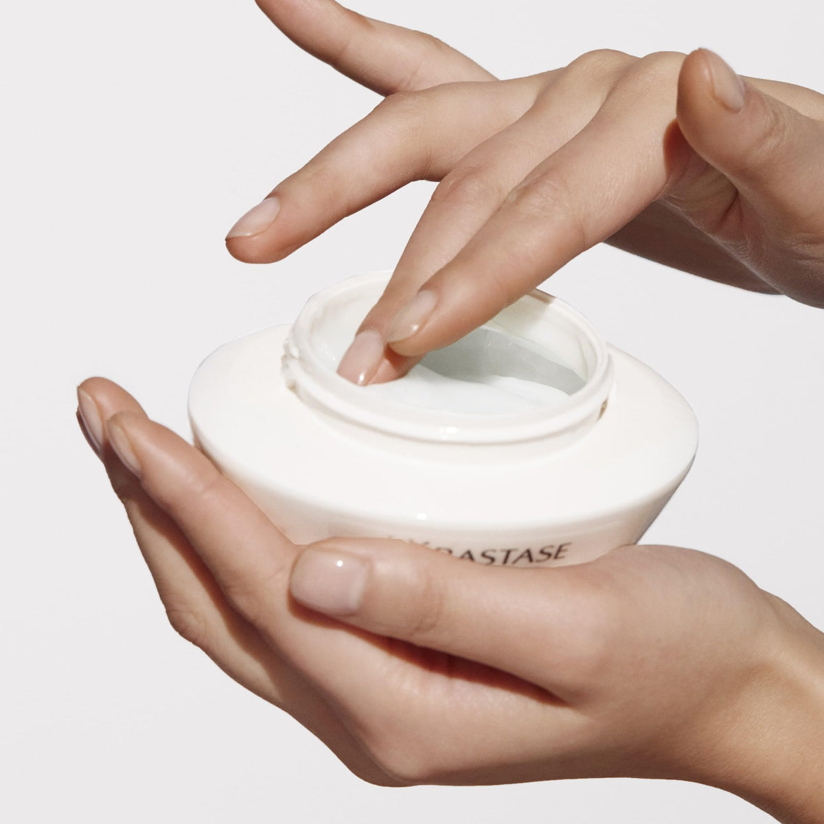KÉRASTASE 6.8 oz jar beside hand to show true size benefit