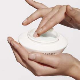 KÉRASTASE 6.8 oz jar beside hand to show true size benefit