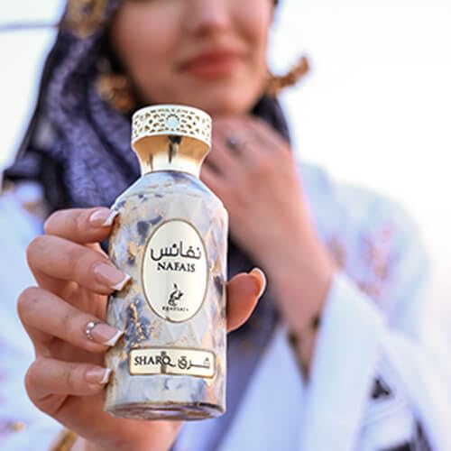 Hand applying Khadlaj Nafais Sharq spray demonstrating daily wear