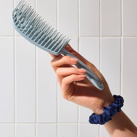 Kitsch brush tucked inside a travel bag for on-the-go styling and maintenance