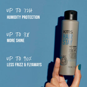 Hand holding KMS HairStay 75ml for scale, highlighting travel-friendly compact size