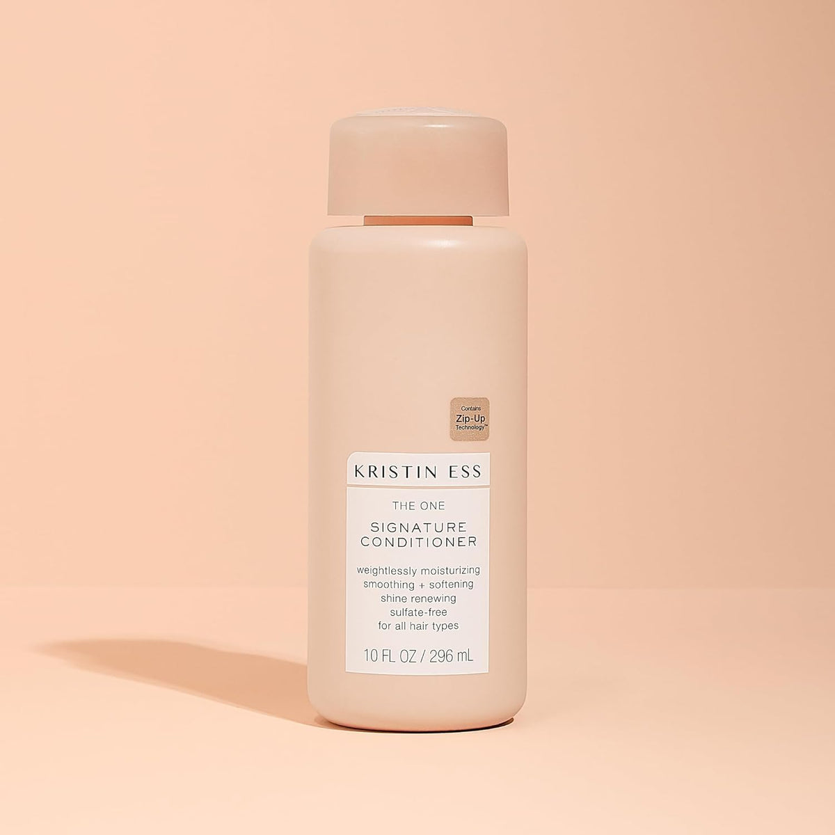 Kristin Ess conditioner applied to wet hair demonstrating detangling benefit