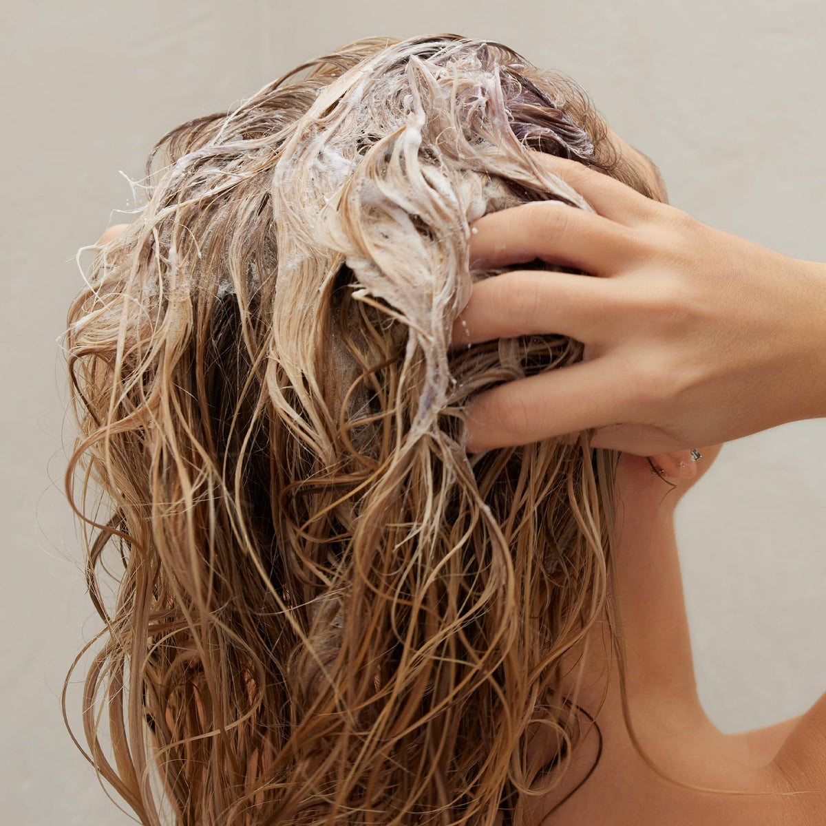 Kristin Ess before and after hair comparison showing reduced brass