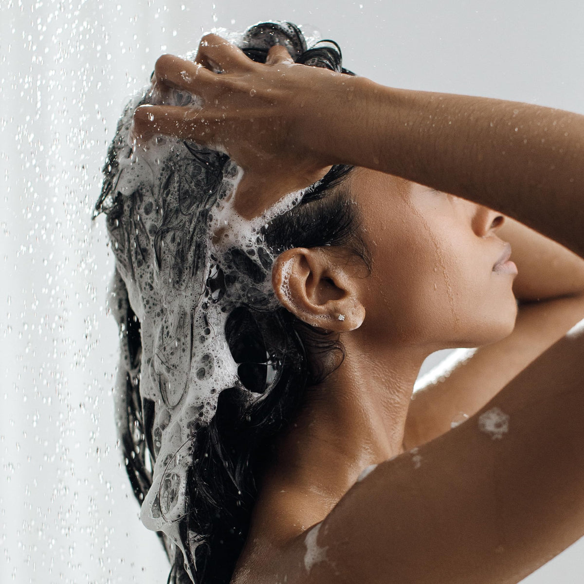 Kristin Ess shampoo staged in bathroom for fresh hair routine benefit