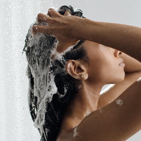 Kristin Ess shampoo staged in bathroom for fresh hair routine benefit