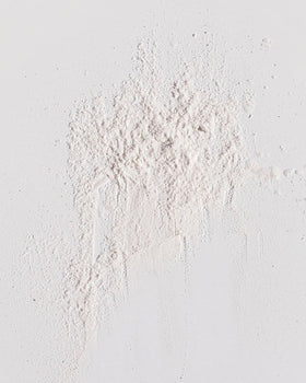 Kristin Ess open jar displaying fine powder texture for quick oil absorption