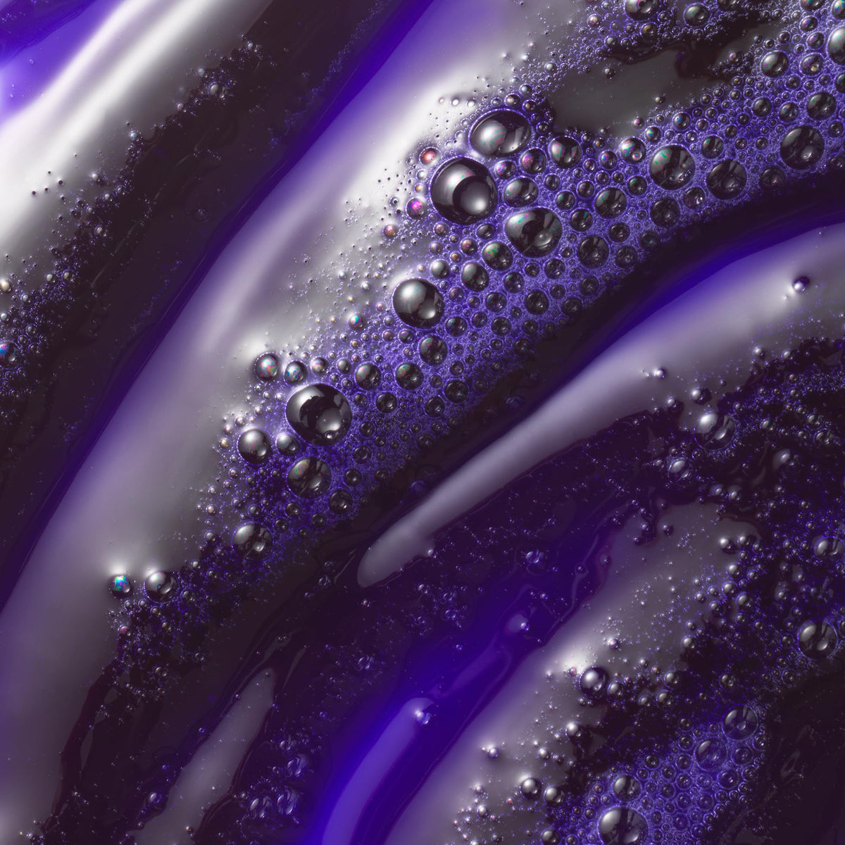 Kristin Ess shampoo poured into palm to show creamy texture and coverage