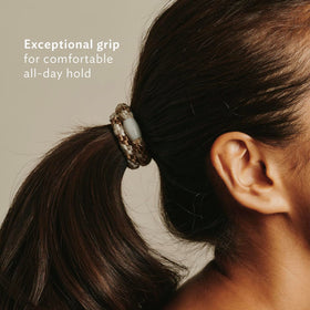 L. Erickson hand holding a hair tie to show size and easy portability benefit